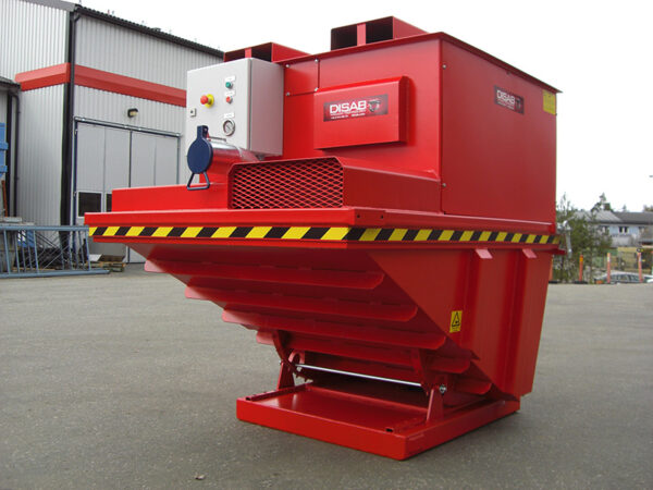 DISAB SkipVAC industrial vacuum system positioned on a concrete surface outside a factory building, highlighting its robust design and mobility for handling dust, spillage, and heavy materials.