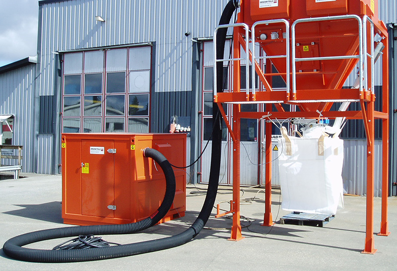 Orange DISAB PES-5 standalone vacuum unit connected via hose to a raised filter separator and big bag, designed for industrial material transport without direct contact with the vacuum system.